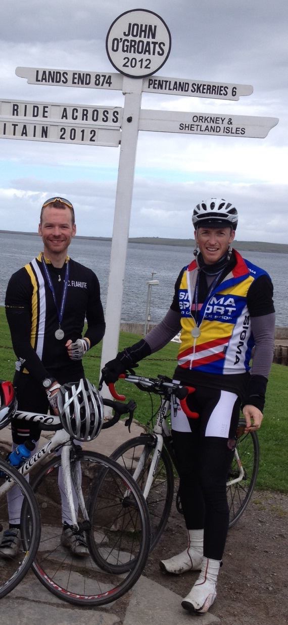 Brendan Ellis and a fellow cyclist at the John O’Groats sign after completing Ride Across Britain